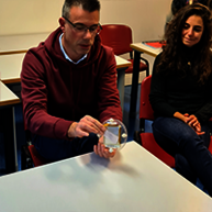 A person manipulates objects during an explanation