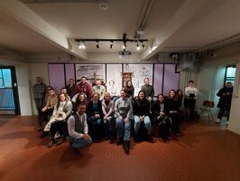 The image depicts a group of people posing for a group photo taken during the event